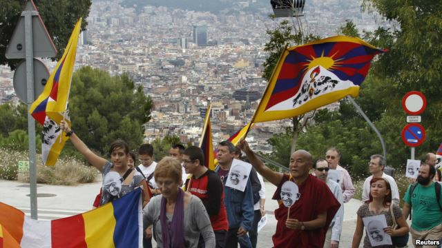 Tu sĩ Phật giáo Thubten Wangchen và những người tham gia cuộc tuần hành 'Vì Hòa bình và Bất bạo động' ở Barcelona, Tây Ban Nha, cầm quốc kỳ Tây Tạng và hình nhà lãnh đạo tinh thần Ấn Độ Mahatma Gandhi, 2/10/10